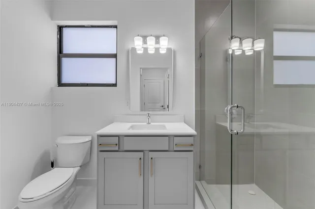 a bathroom with a toilet a sink and mirror