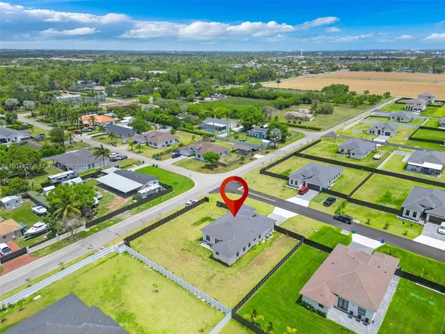 an aerial view of residential houses with outdoor space and swimming pool