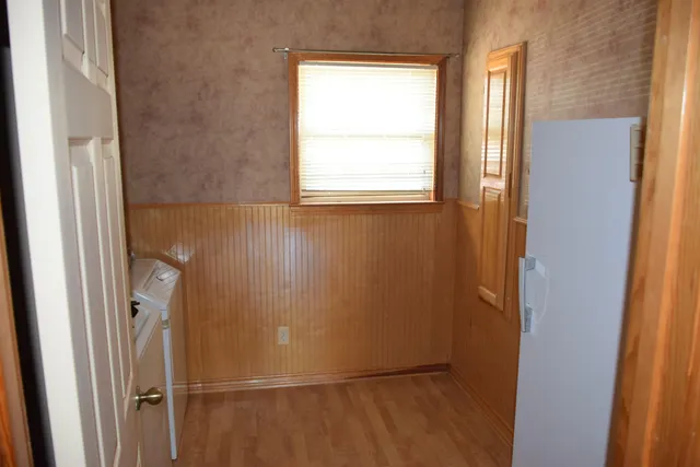 a view of a small space with wooden floor and a window