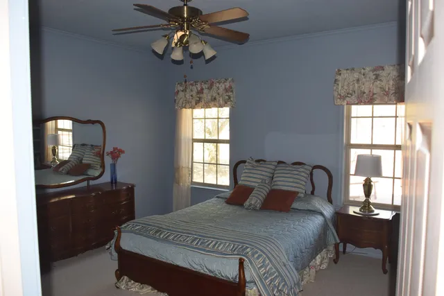 a bedroom with a bed and a dresser next to a window