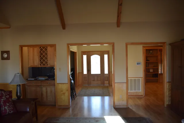 a view of a hallway with wooden floor windows and a livingroom