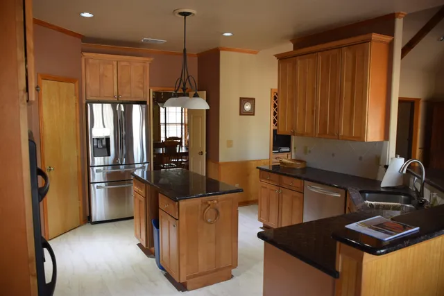 a kitchen with stainless steel appliances granite countertop a refrigerator and a stove top oven
