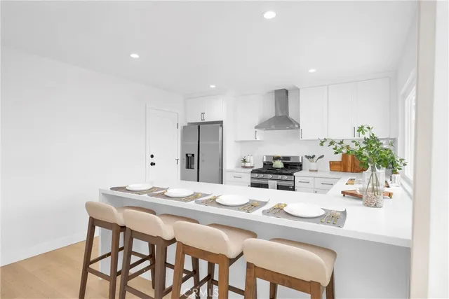 a kitchen with stainless steel appliances kitchen island granite countertop a dining table and chairs