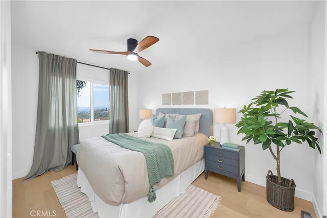 a bedroom with a large bed and a potted plant