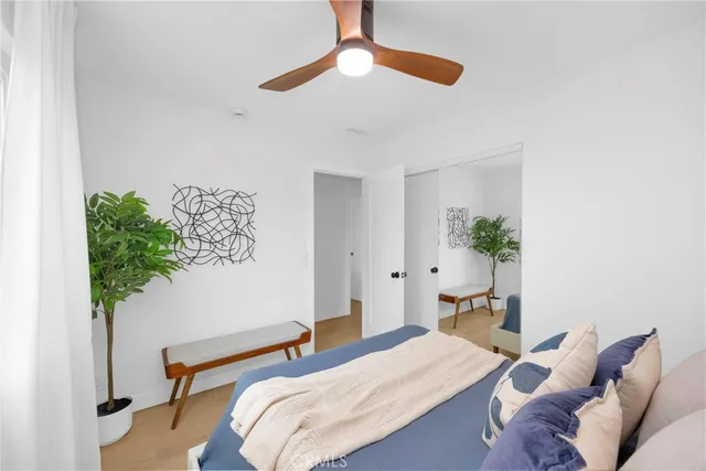 a bedroom with a bed and a potted plant