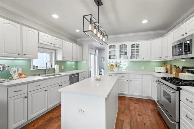 a kitchen with granite countertop white cabinets and white appliances