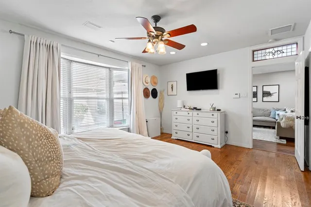 a bedroom with a large bed and a flat tv screen on dresser