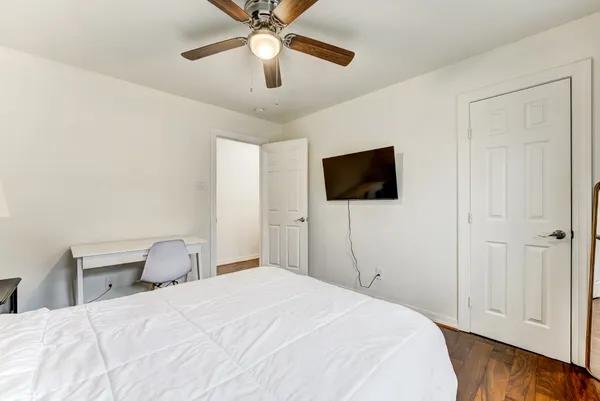 a spacious bedroom with a bed and a flat screen tv