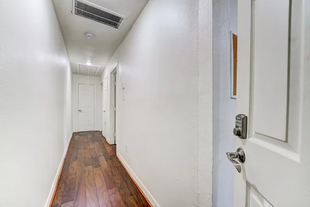 a view of a hallway with wooden floor