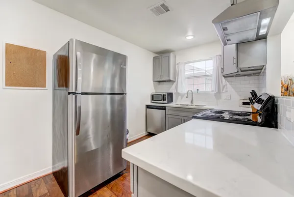 a kitchen with stainless steel appliances a refrigerator sink and cabinets