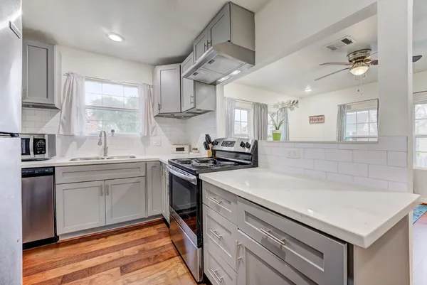 a kitchen with stainless steel appliances granite countertop a stove and a white cabinets