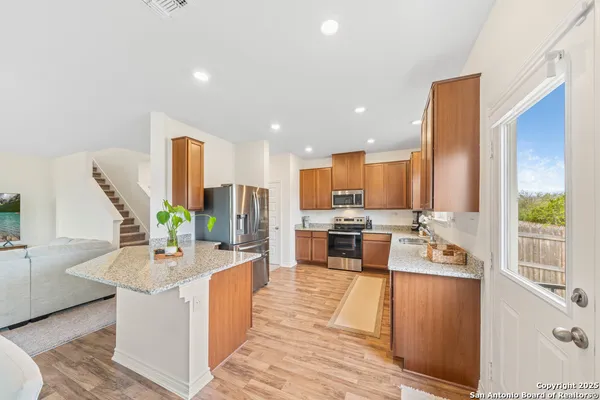 a large kitchen with stainless steel appliances kitchen island granite countertop a large counter top appliances and cabinets