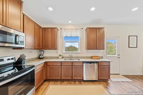 a kitchen with a sink a stove cabinets and a window