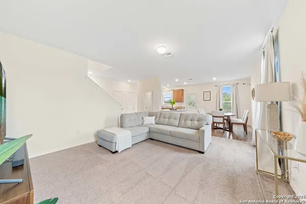 a living room with furniture white refrigerator and a couch