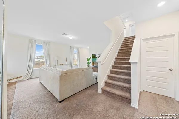a view of a livingroom with furniture and stairs