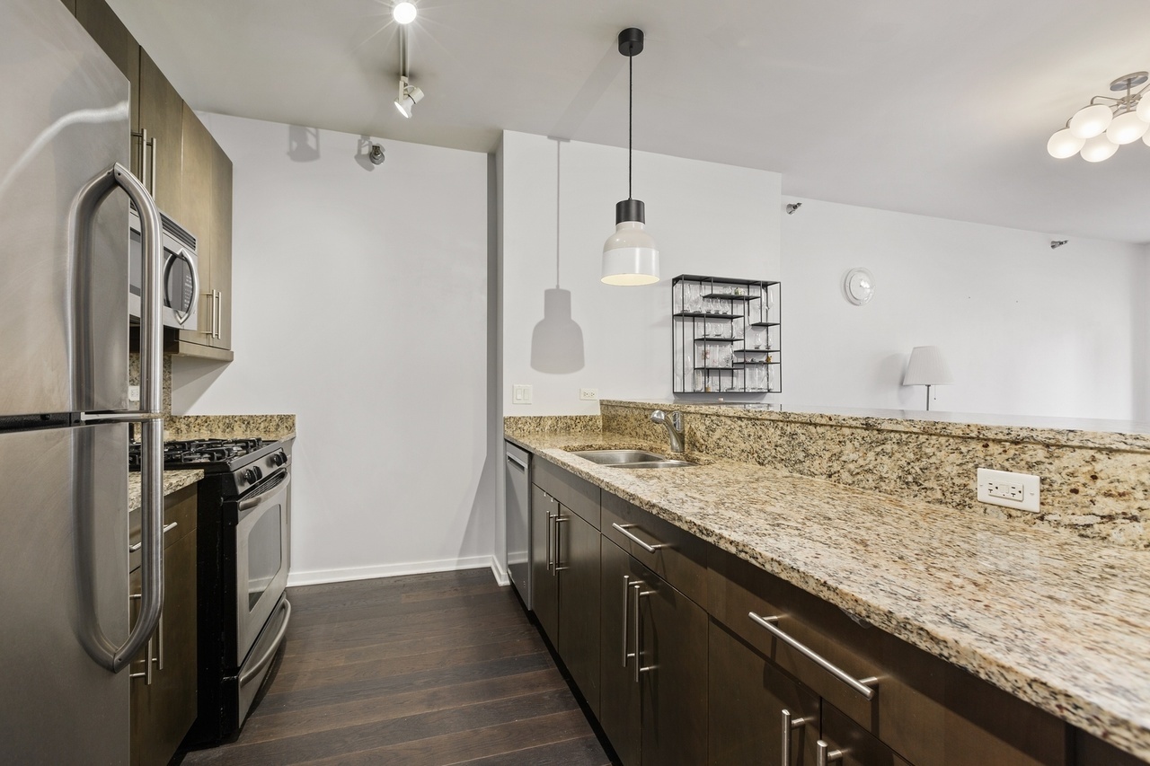 Undisclosed Address Chicago, IL 60607 - Photo 3 of 13 a kitchen with stainless steel appliances granite countertop a sink a stove and a refrigerator