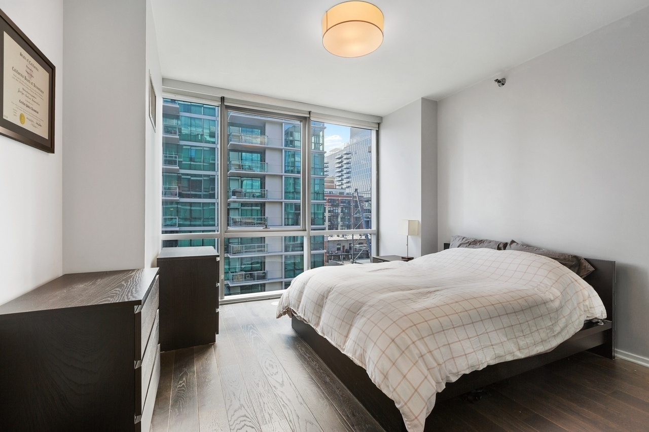 Undisclosed Address Chicago, IL 60607 - Photo 8 of 13 a bedroom with a bed and a large window