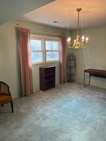 a view of a room with a chair and potted plant