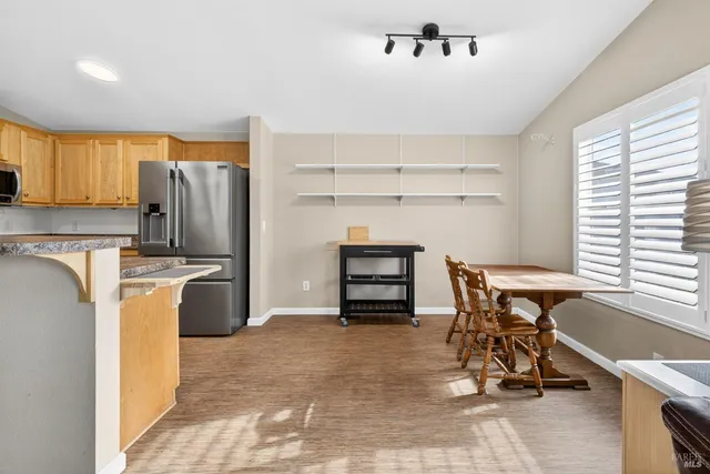 a view of a kitchen with refrigerator and dining table