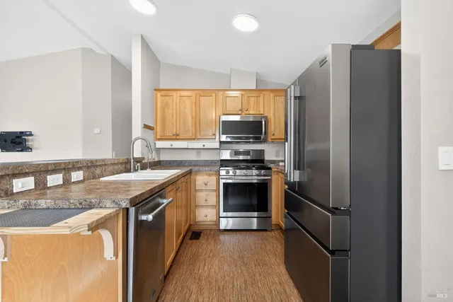 a kitchen with stainless steel appliances granite countertop a refrigerator stove and sink