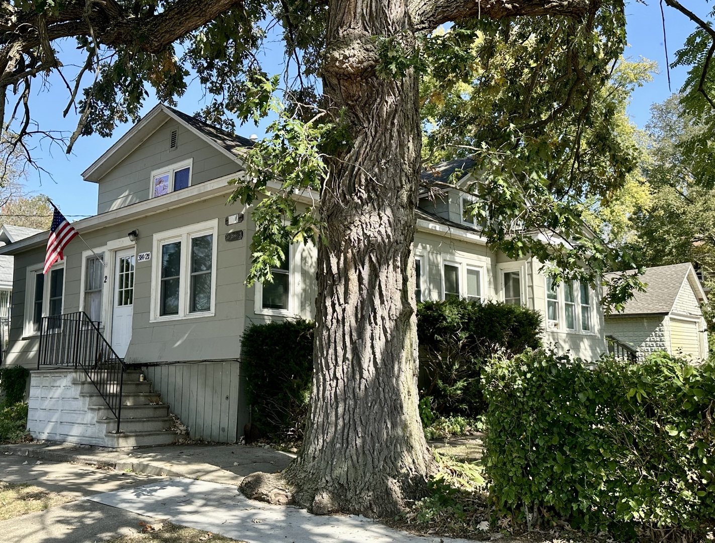 a front view of a house with a tree