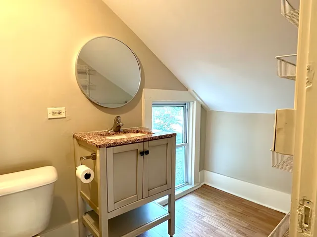a bathroom with a granite countertop sink a toilet and a mirror