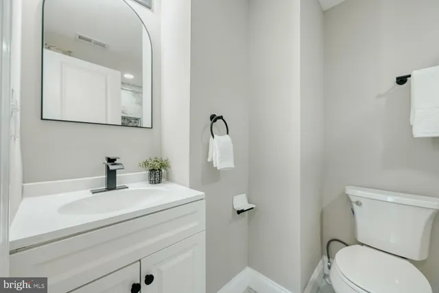a bathroom with a sink mirror and toilet