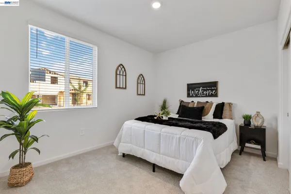 a bedroom with a bed lamp and a potted plant