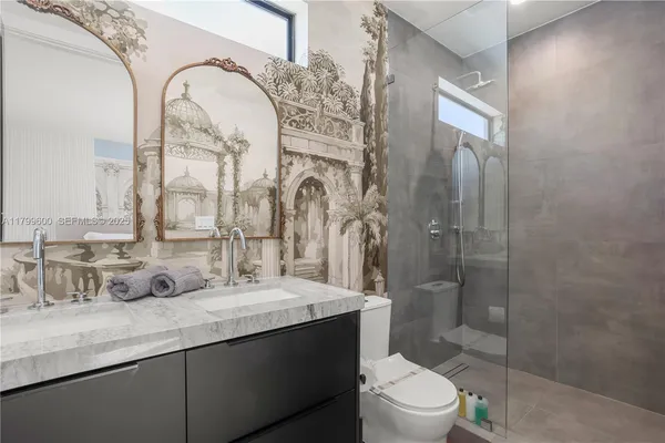 a bathroom with a granite countertop sink mirror toilet and shower