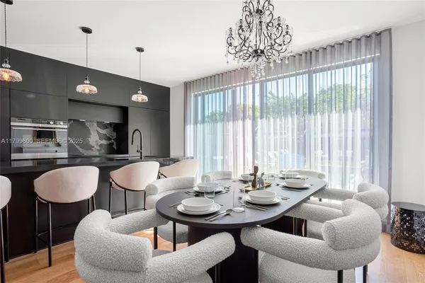 a view of a dining room with furniture a chandelier and wooden floor