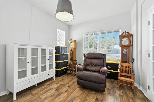a living room with furniture and a large window with kitchen view