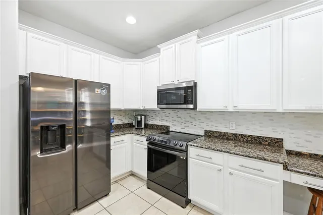 a kitchen with stainless steel appliances granite countertop a refrigerator and a stove