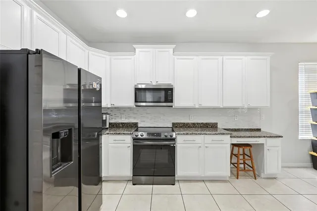 a kitchen with white cabinets and appliances
