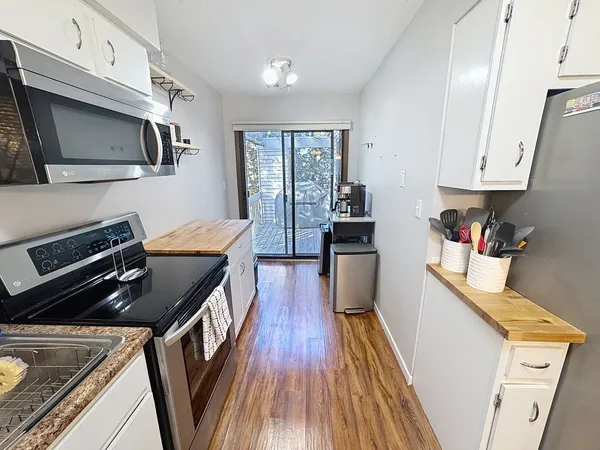 a kitchen with wooden floors and appliances