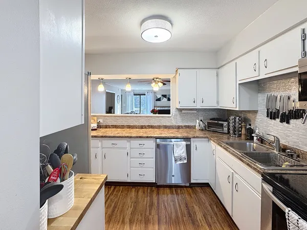 a kitchen with granite countertop white cabinets and white appliances
