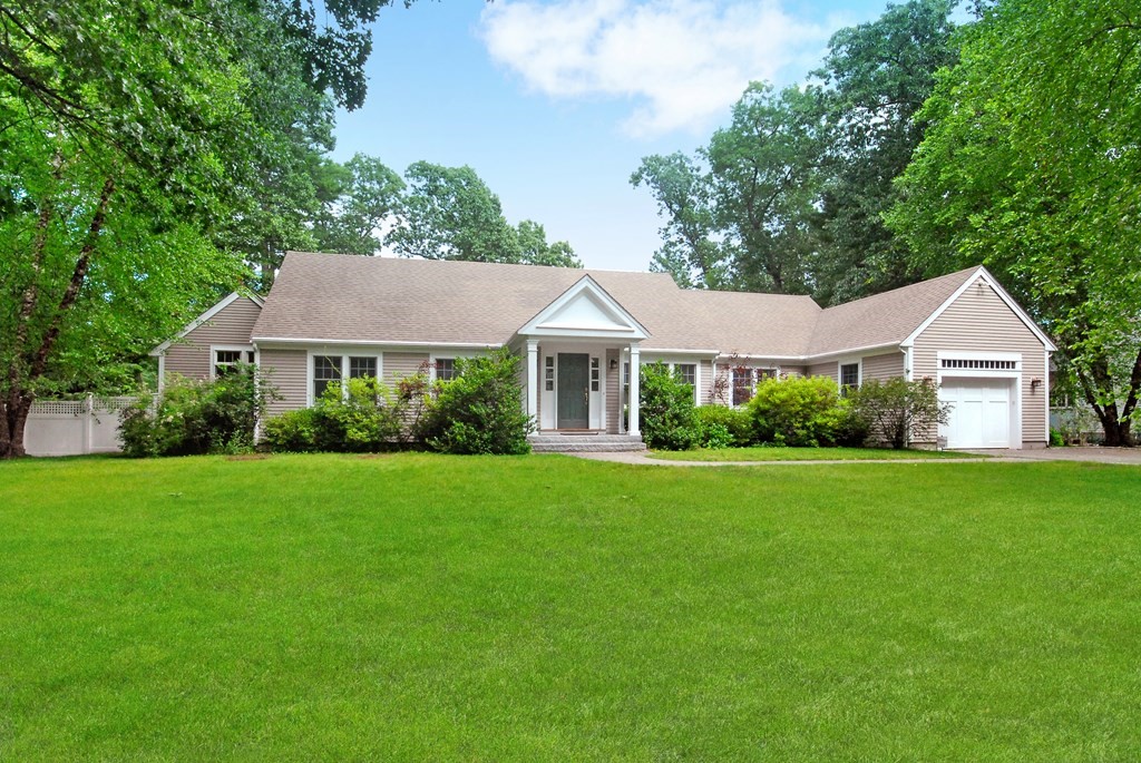 a front view of a house with a yard and trees