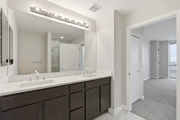 a bathroom with double vanity and a mirror