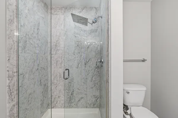 a bathroom with a toilet and a shower