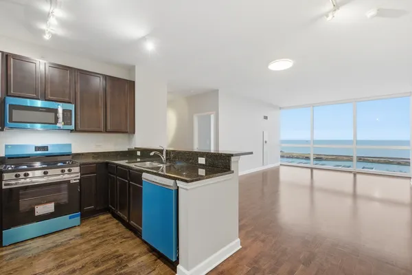 a kitchen with kitchen island a stove a sink and a microwave