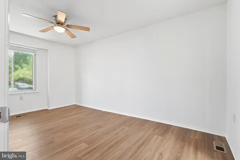 an empty room with a window and a ceiling fan