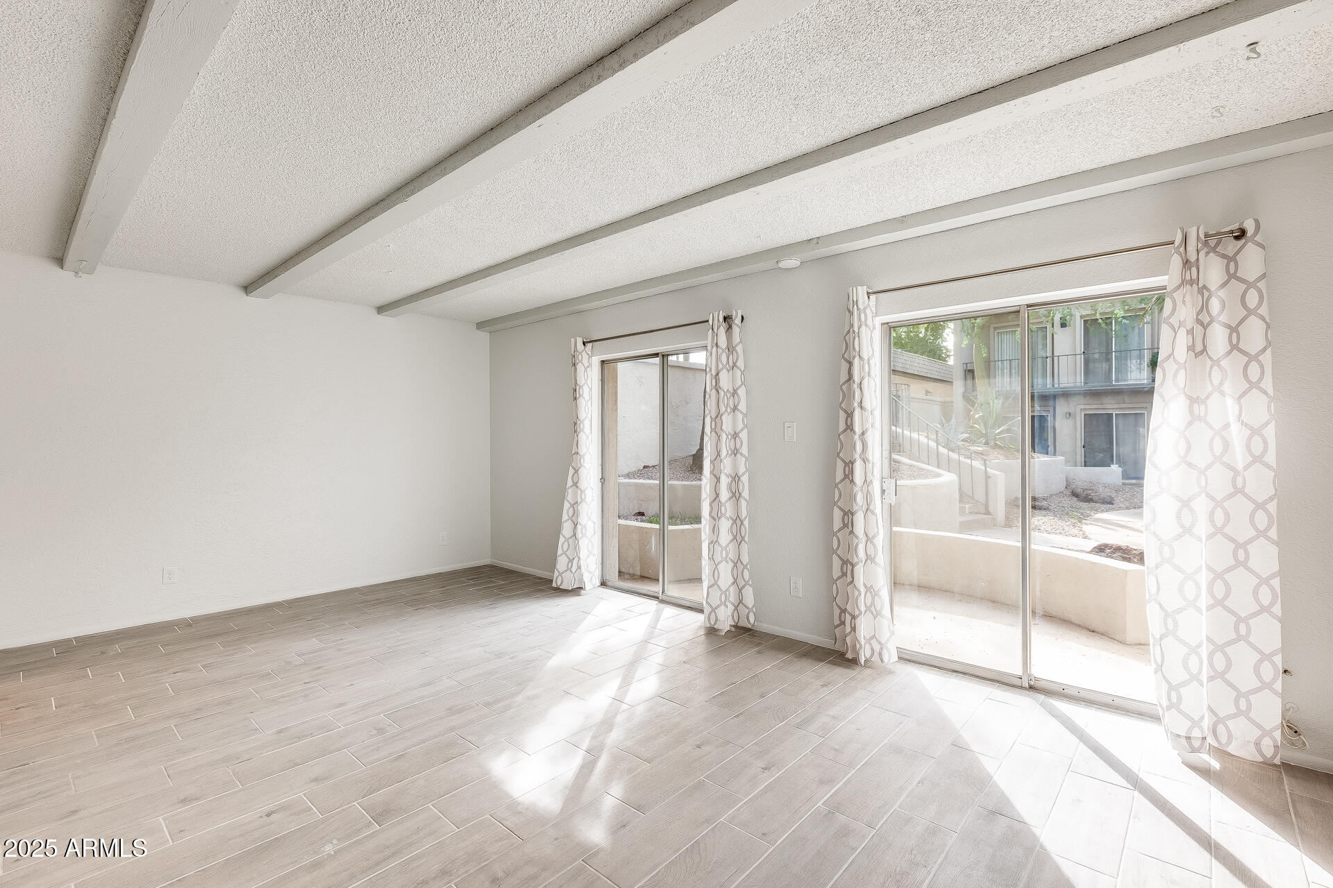 1024 East Osborn Road, Unit A Phoenix, AZ 85014 - Photo 4 of 20 an empty room with sliding glass door and shower