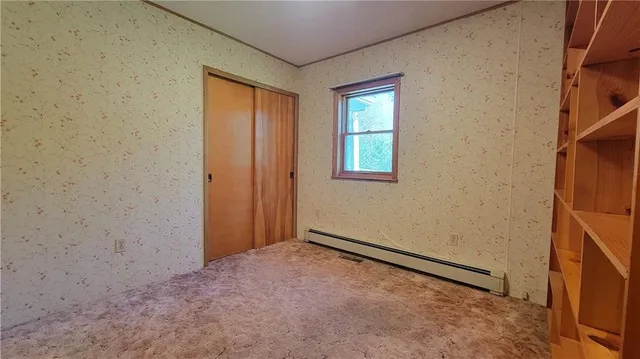 a view of room with wooden floor and cabinets