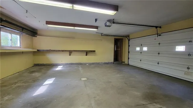 a view of an empty room with window and a fireplace