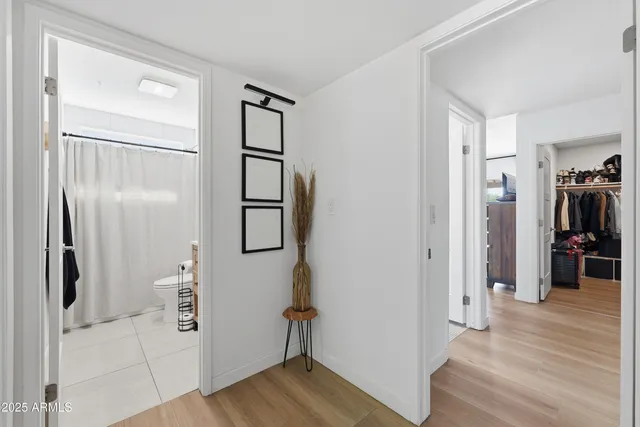 a view of a hallway with wooden floor and closet