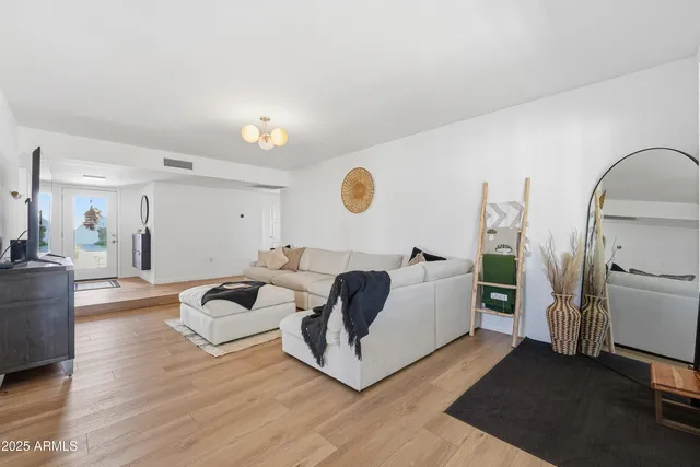 a living room with furniture mirror and a wooden floor
