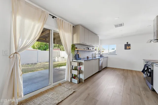 a view of a kitchen with fridge and wooden floor