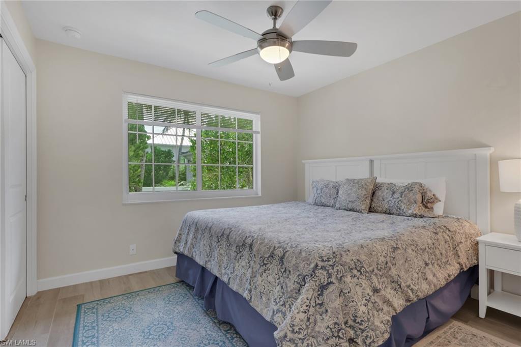 230 3rd Avenue South, Unit 4 Naples, FL 34102 - Photo 12 of 22 a bedroom with a large bed and a chandelier fan