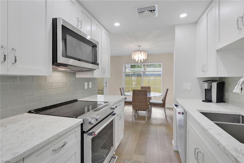 230 3rd Avenue South, Unit 4 Naples, FL 34102 - Photo 4 of 22 a kitchen with a stove a sink and a microwave