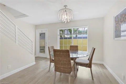 a view of a dining room with furniture a chandelier and wooden floor