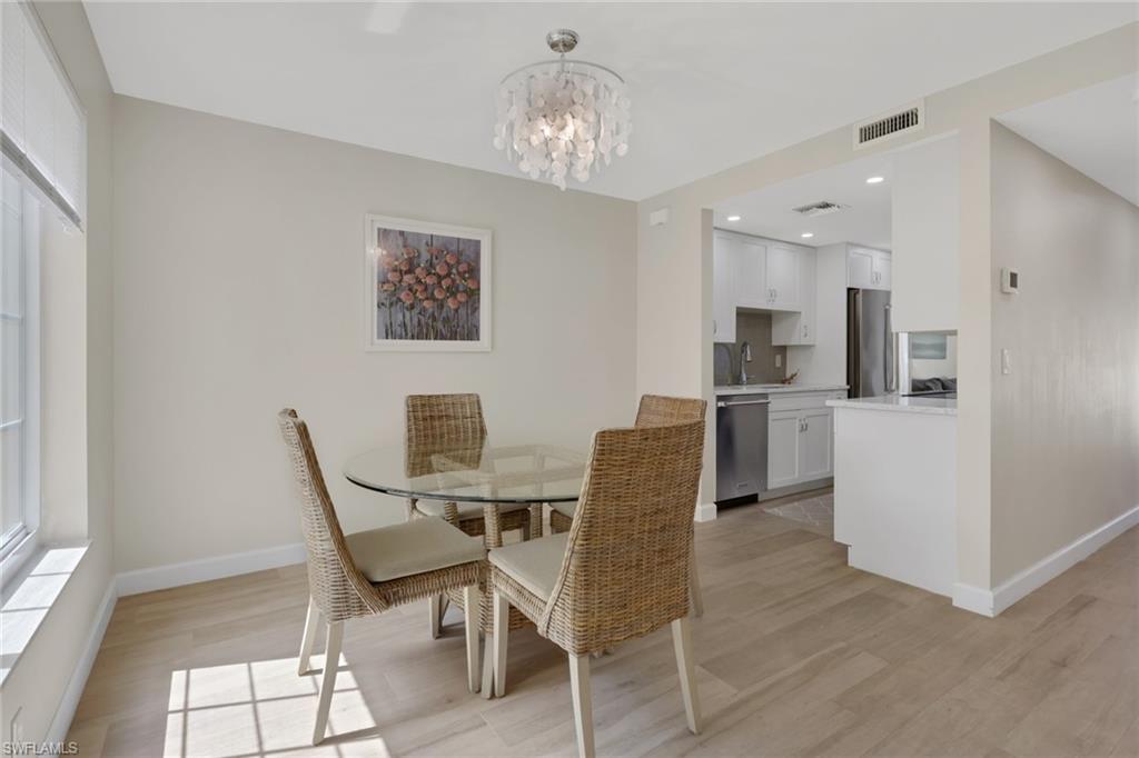 230 3rd Avenue South, Unit 4 Naples, FL 34102 - Photo 6 of 22 a view of a dining room with furniture and chandelier